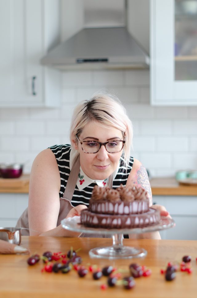 Woman decorating chocolate cake