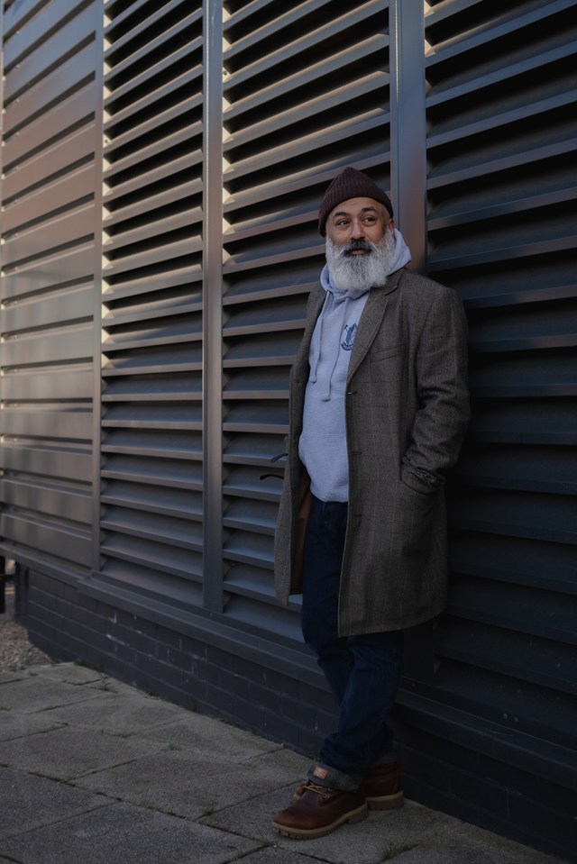Portrait of man standing against shutters